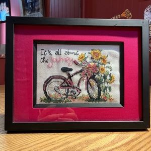 Framed cross stitch piece with bike and flowers.